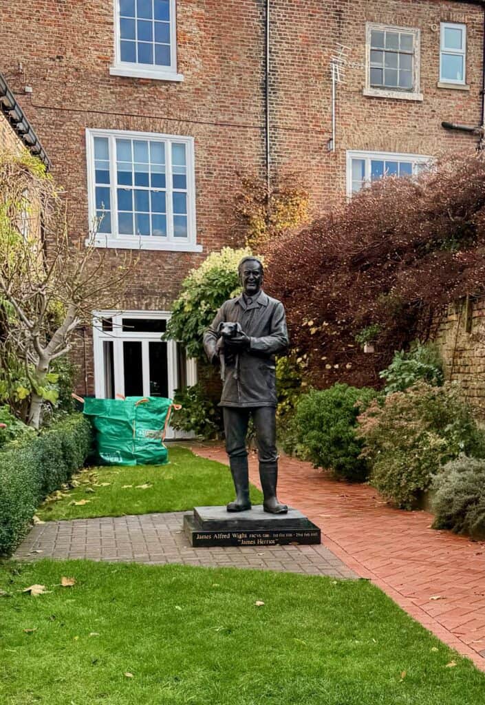 Bronze statue of Alf Wight the rural Yorkshire vet stands in the middle of a Thirsk courtyard at his museum