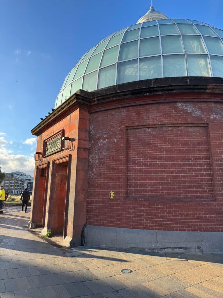 Brick and glass entrance to a tunnel beneath the Thames River between Greenwich London and the Isle of Dogs