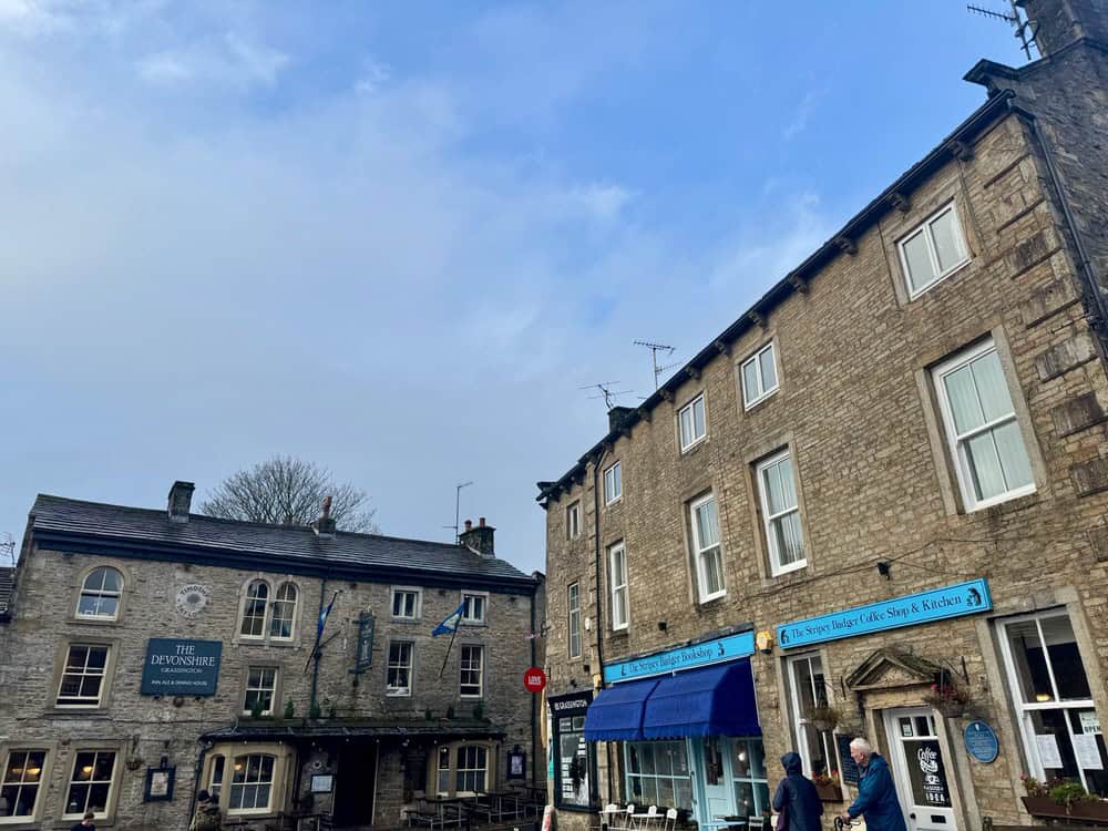 Stone buildings including a pub and bookstore in a Yorkshire Dales village.