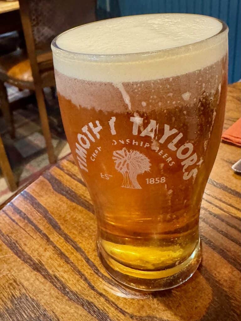 A pint of cask ale sits on a pub table