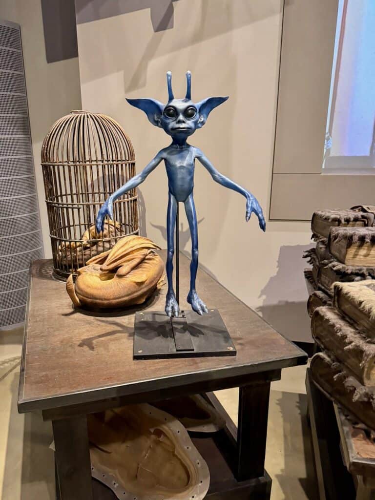 A blue Cornish Pixie prop sits on a table on the Making of Harry Potter Tour London