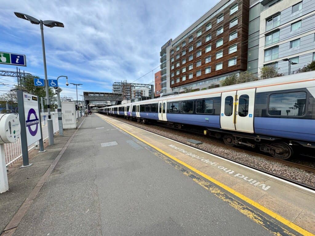 A purple Elizabeth line London transport train at an outside station