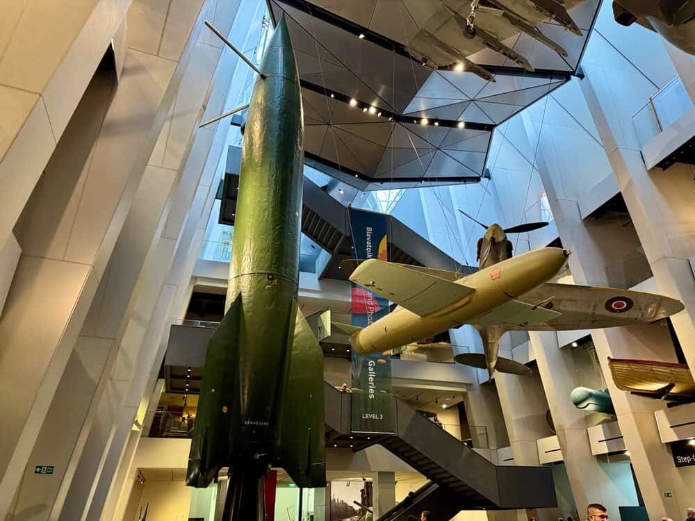 Missiles and World War II aircraft hang from the ceiling in the Imperial War Museum Lambeth entrance hall