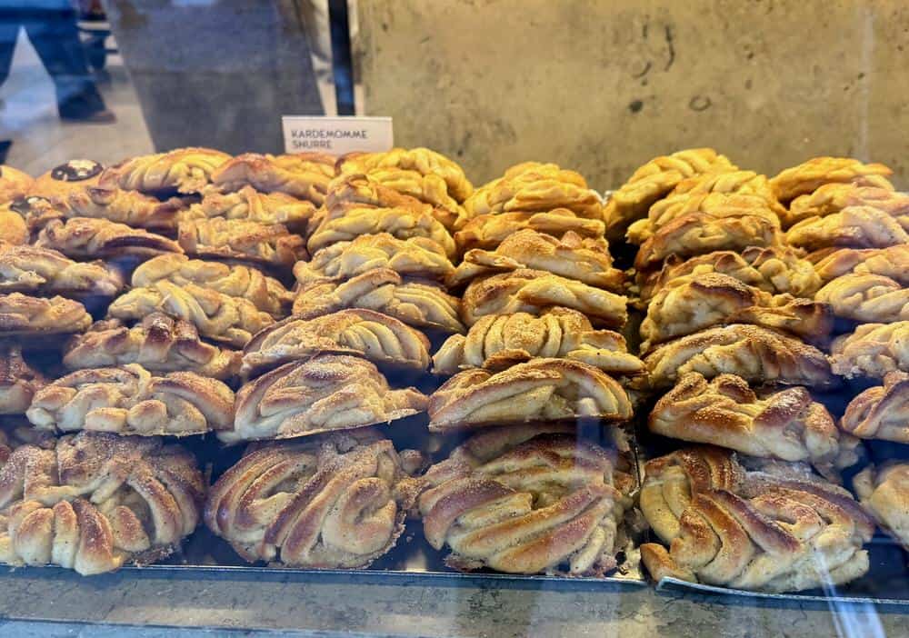 Stacks of cardamom bun twisted rolls in a Copenhagen bakery window