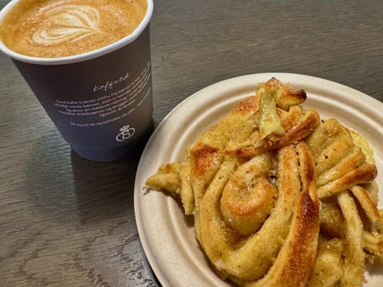 Cup of coffee and a plate with a cardamom twist pastry in Denmark