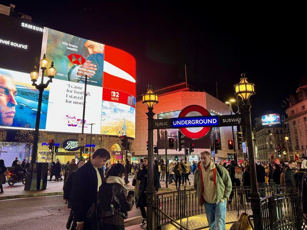 London pedestrians come and go from the public subway Tube entrance at Piccadilly Circus