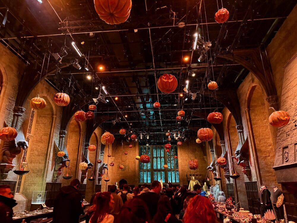 Decorative carved pumpkins hang over visitors' heads inside the Hogwarts Great Hall set in Warner Bros Studio London