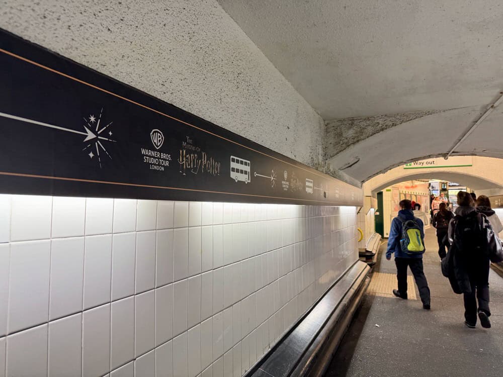 People walk in the tunnel beneath the train tracks at Watford Junction station towards the Warner Bros Studio London shuttle bus area