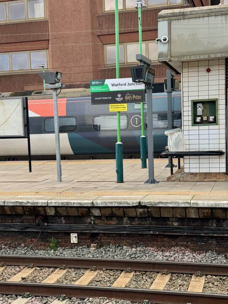 Looking across train tracks at Watford Junction station at the station arrival signs