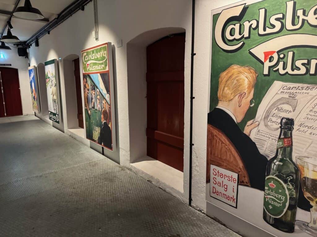 Historic Carlsberg beer posters line the halls in the brewery tour exhibition