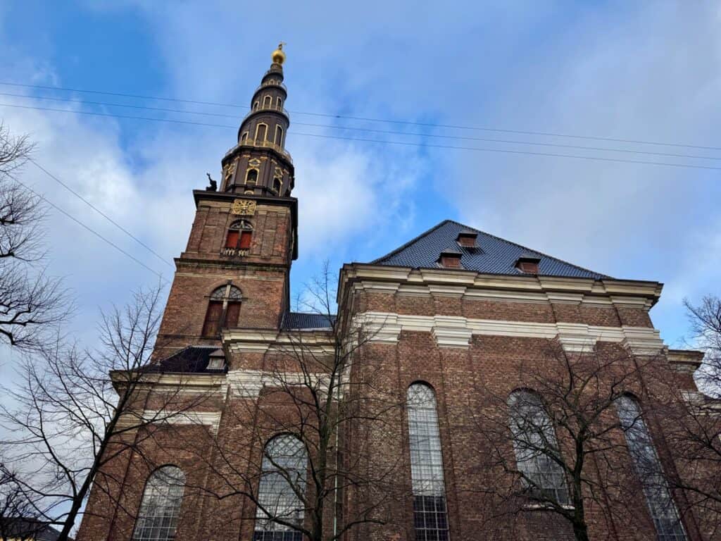 Brick church with a distinctive spiral spire with an exterior staircase wrapping around the spire.