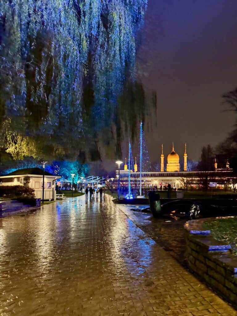 Pathway through Malmo Folkets Park after dark with light displays and Moorish pavillion in the background.