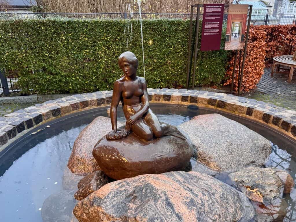Bronze figurine of a naked woman on a fountain of rocks