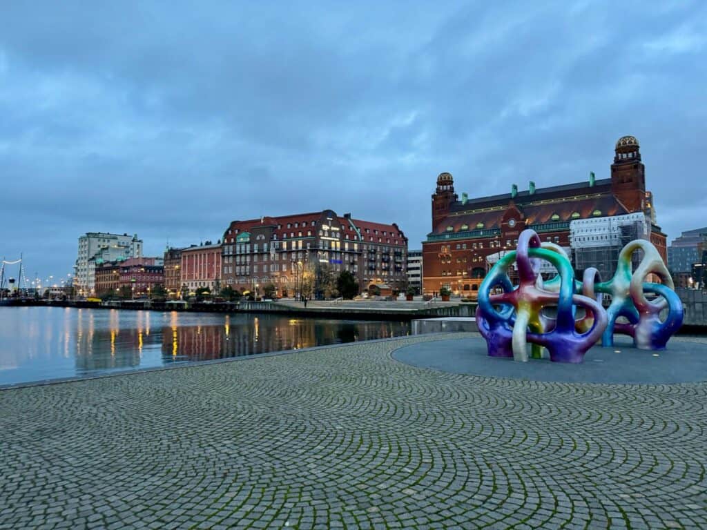 Large artwork installations and historic building line the Malmo harbor and canals