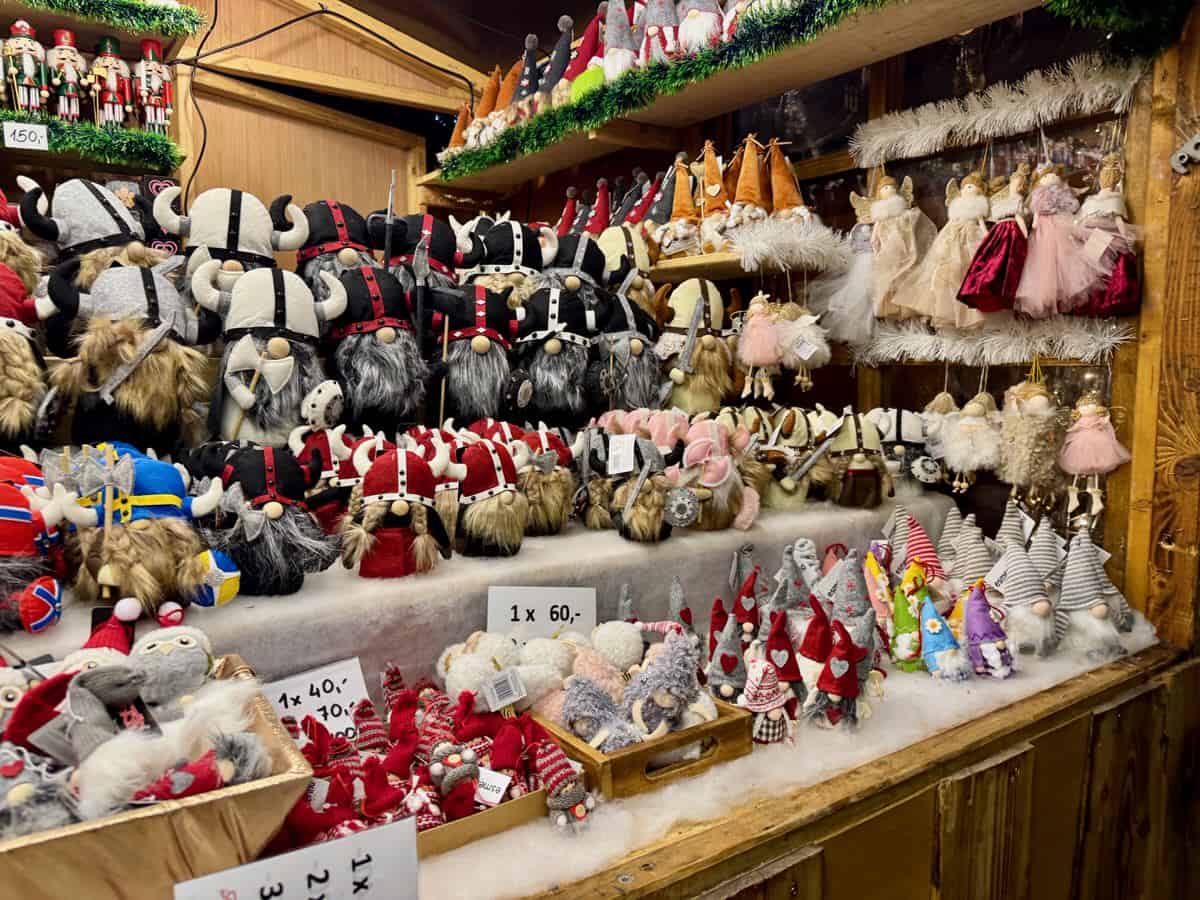 A Christmas market booth filled with nisse figurines in all different colors, sizes, and costumes.