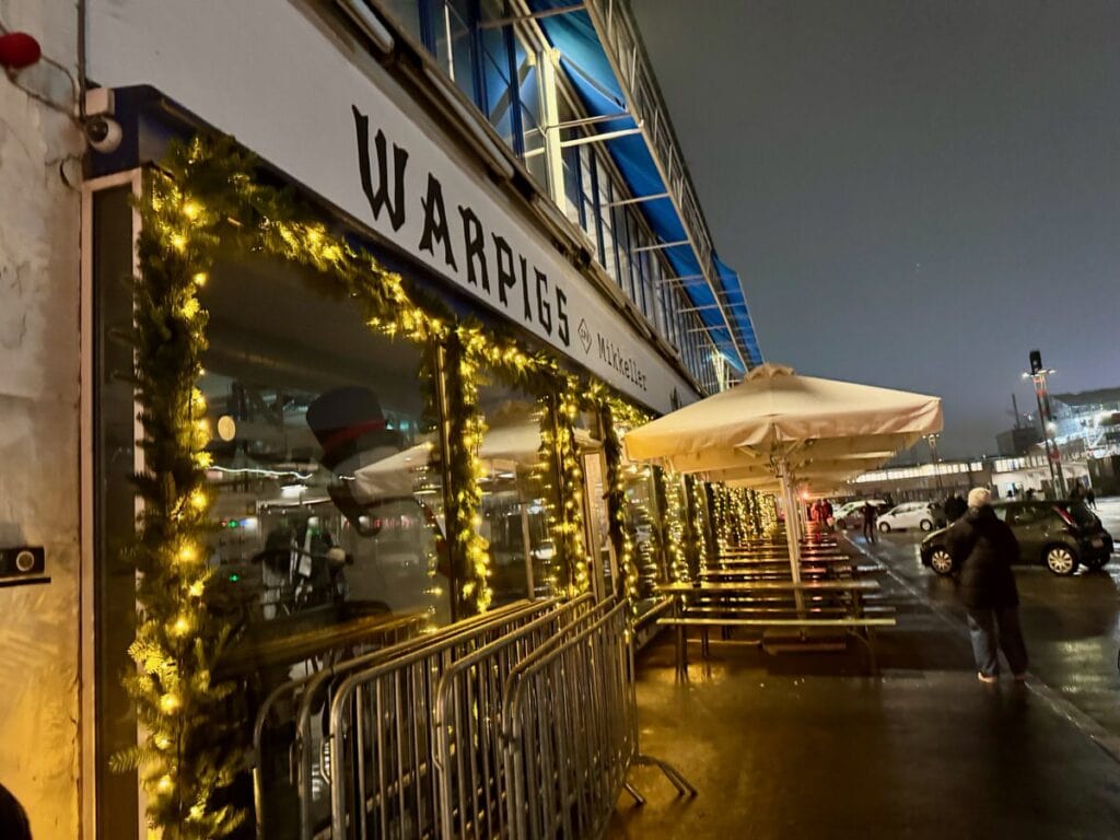 Copenhagen meatpacking district restaurant with windows lined with lit evergreen garlands