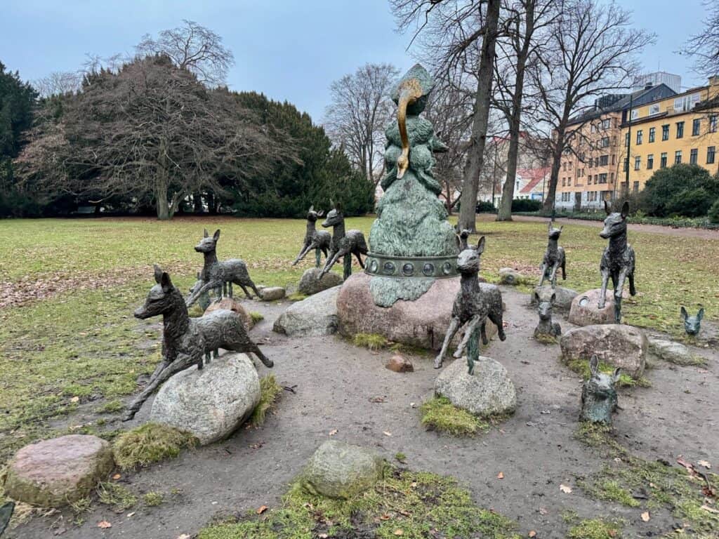 Bronze fawn sculptures surround a sculpture of a goose in a Malmo City park