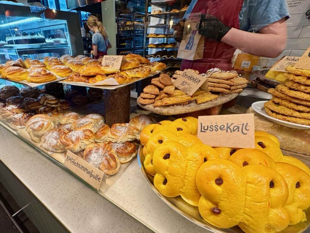 A selection of Swedish baked goods including cardamom rolls, lussekalt rolls, and more in a bakery case