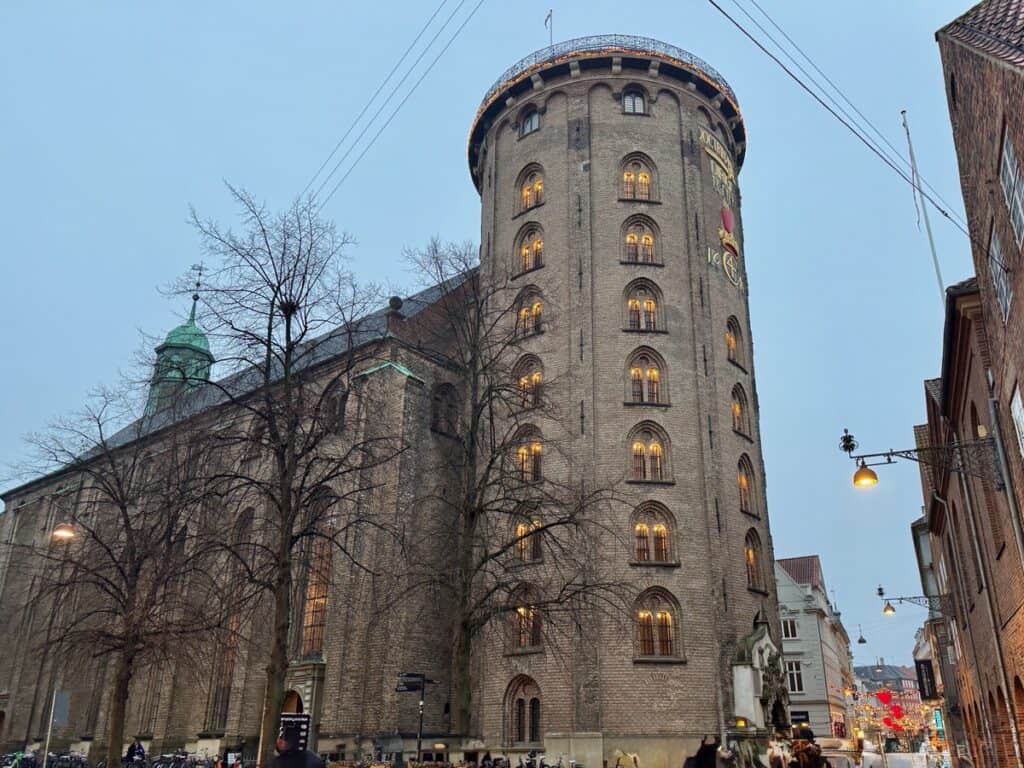 Red brick seven story tower attached to a brick building in the historic University of Copenhagen