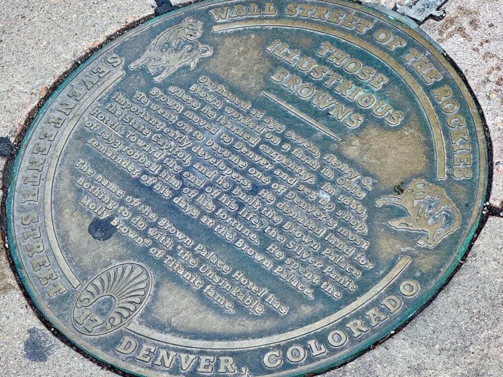 A plaque inlaid in the sidewalk outside Brown's Palace Hotel in downtown Denve explaining the hotel's history.