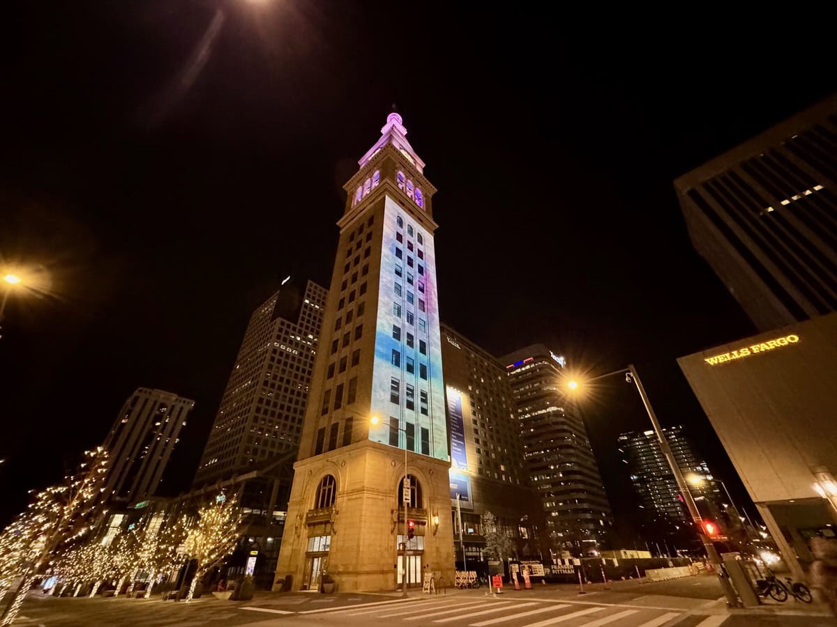 Italianate clock tower in downtown Denver with light projections after dark.