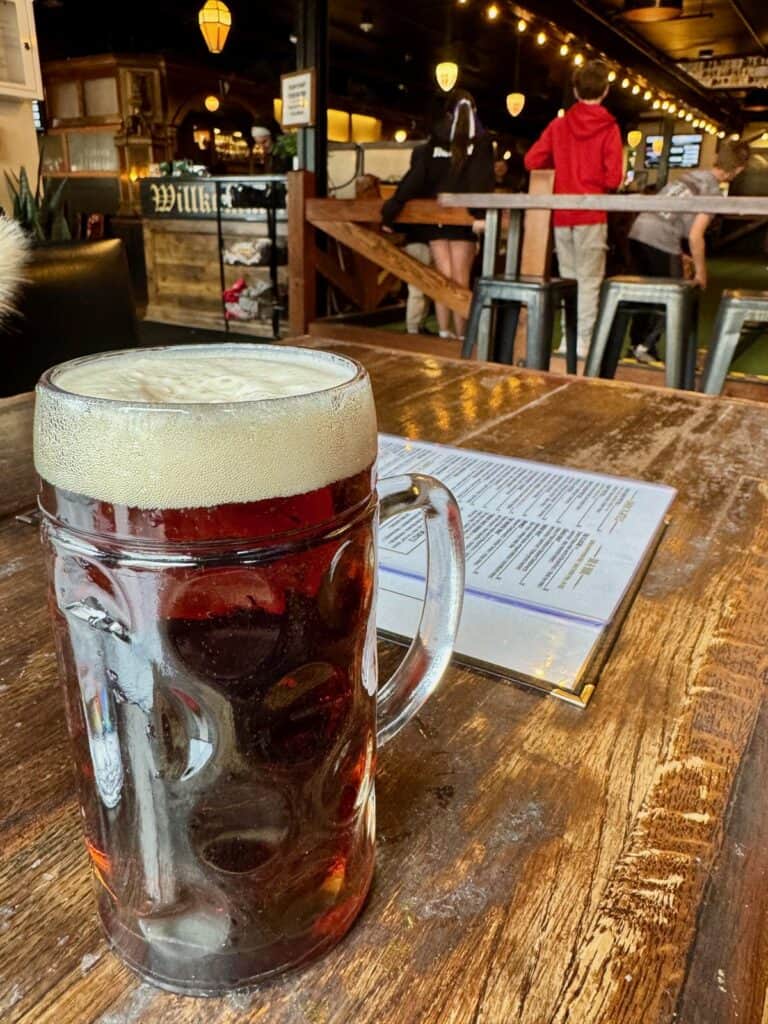 A mug of beer on a wooden table in a bar