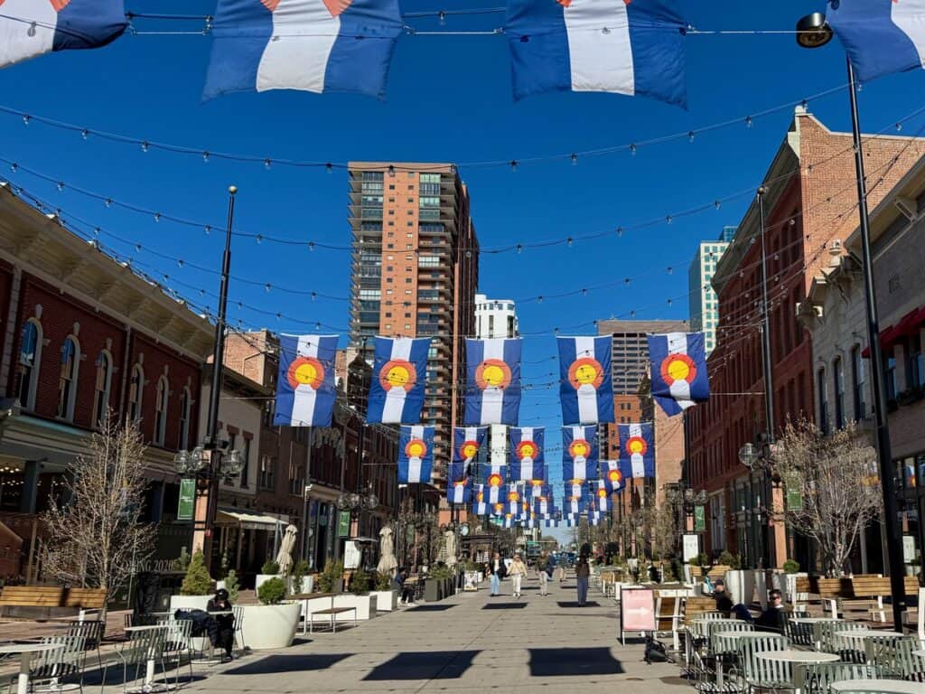 Colorado state flags hang in Larimer Square pedestrian plaza shopping area