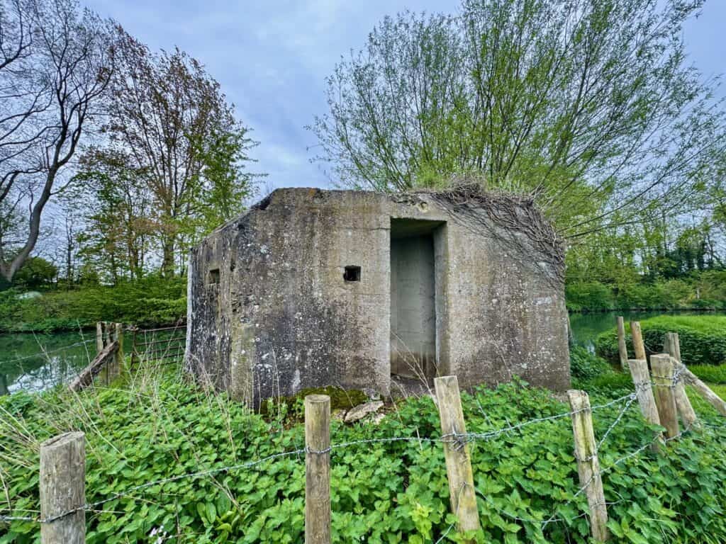 Concrete defense structure from World War II on the banks of the Thames River in spring.