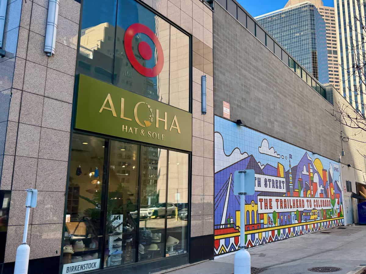 An entrance to Aloha and Target stores next to a colorful tile mural in downtown Denver