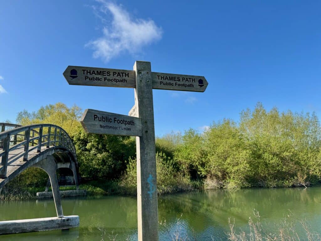 Directional sign and footbridge over the Thames River near Oxford