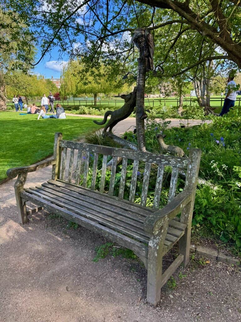 Park bench with a statue with animal figurines in Oxford Botanic Gardens