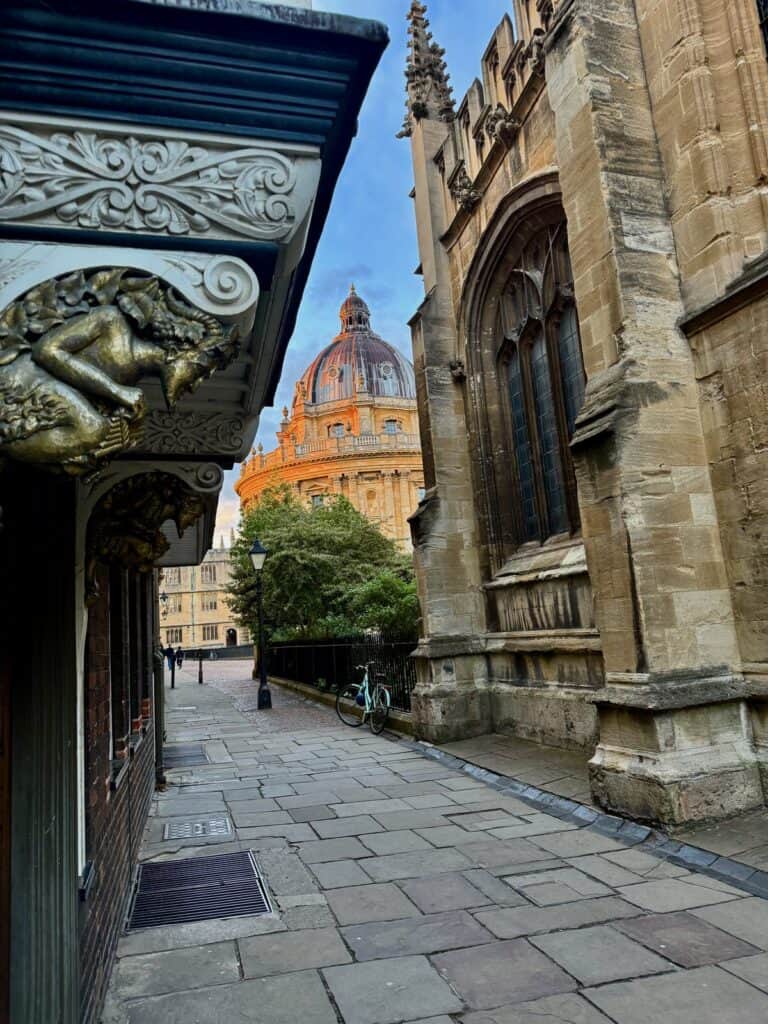Fawn figurine over a doorway in St. Mary's Passage with lamppost and Radcliffe Camera in the background
