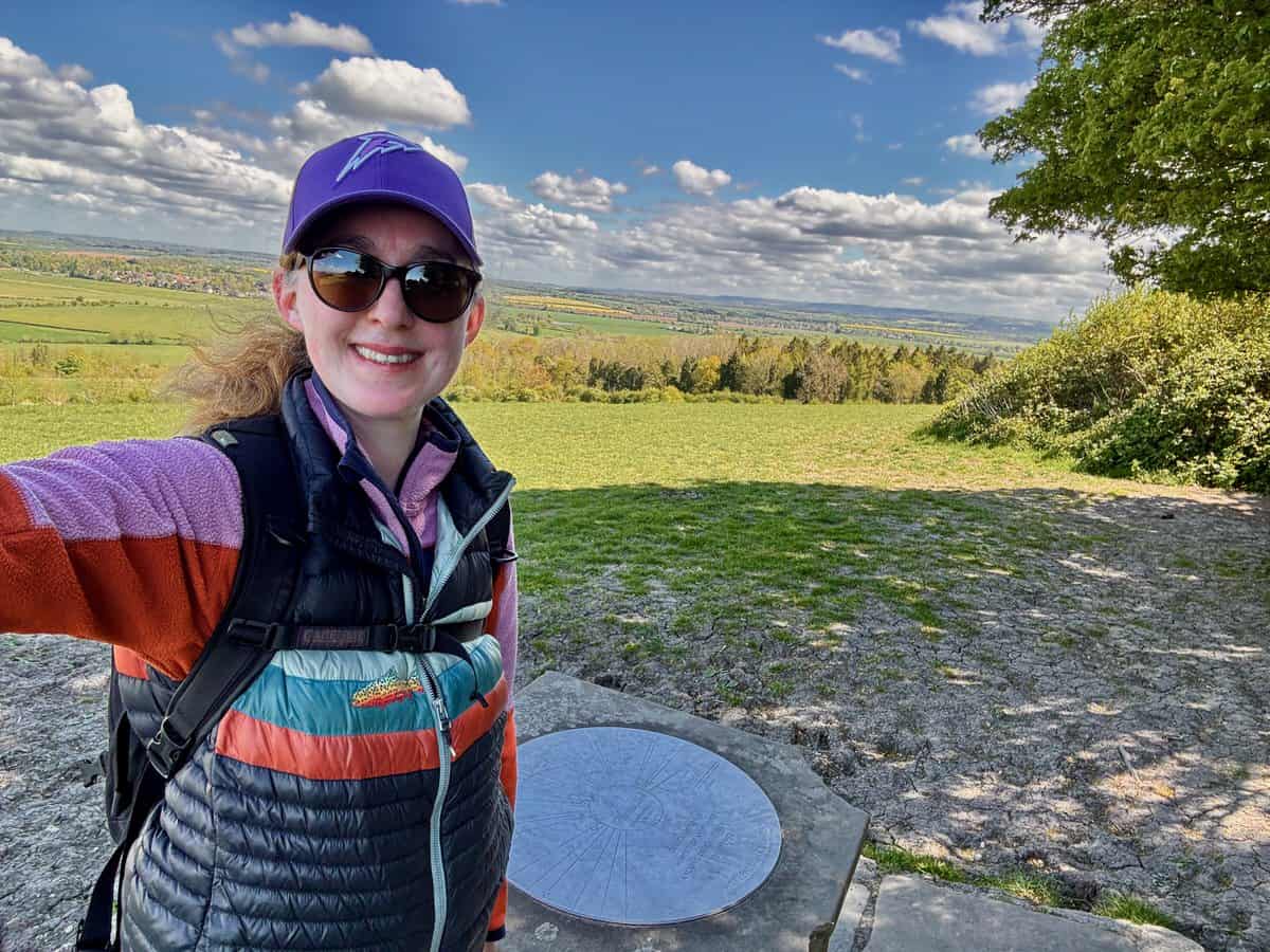 Woman poses for a selfie at the top of a hill overlooking the Thames River valley