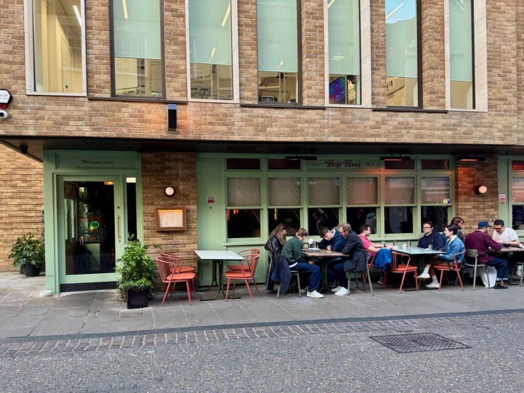 Diners sit at outside tables in front of a popular Indian food restaurant in central Oxford