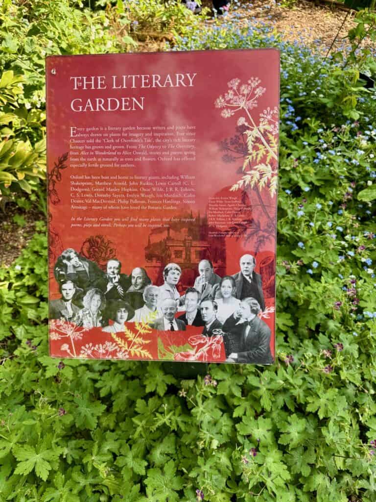 Red outdoor sign describing the literary garden inside Oxford Botanic Garden