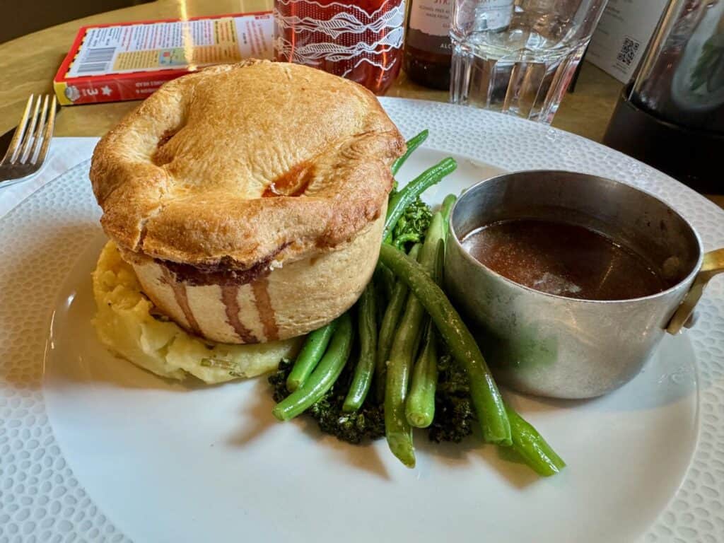 A savory pie with mashed potatoes, gravy, and roast vegetables