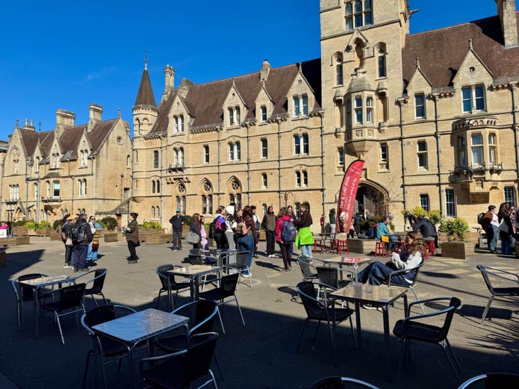 Walking tour groups gather on Oxford's Broad Street in front of Balliol College Porters' Lodge